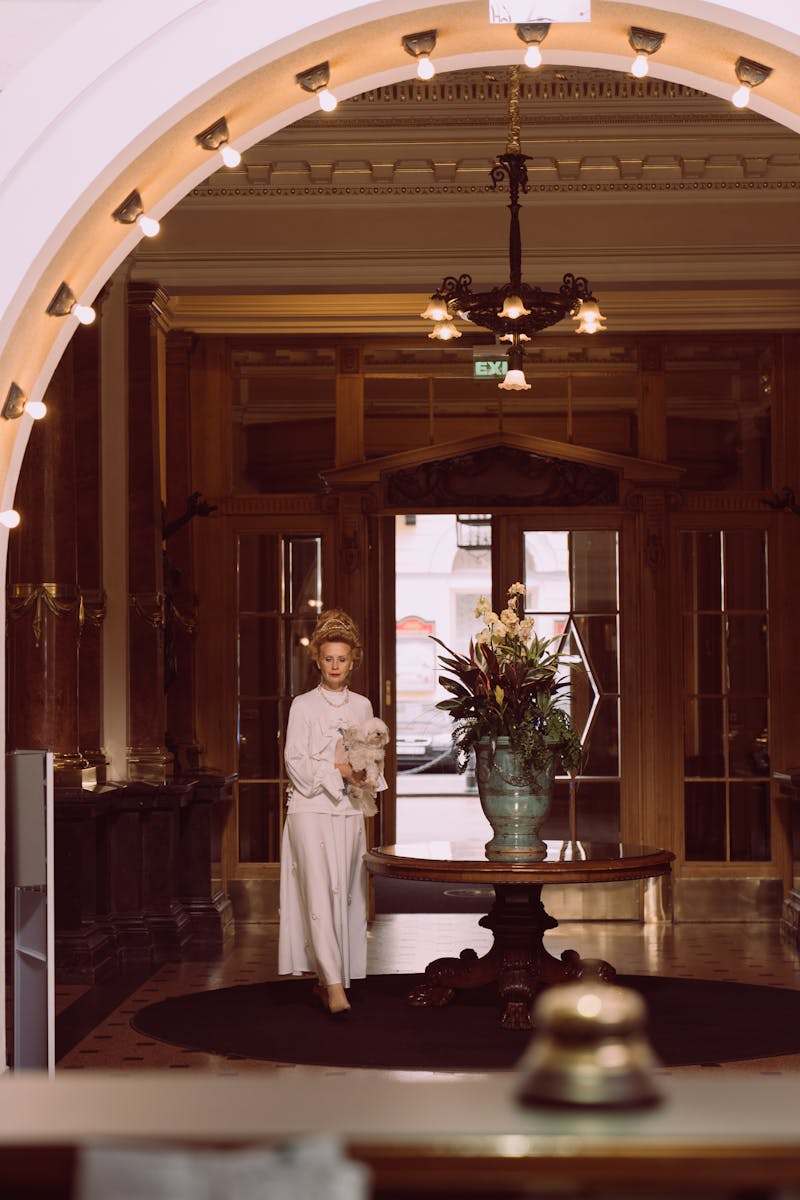Luxurious hotel lobby featuring elegant interior design with a grand archway and floral centerpiece.