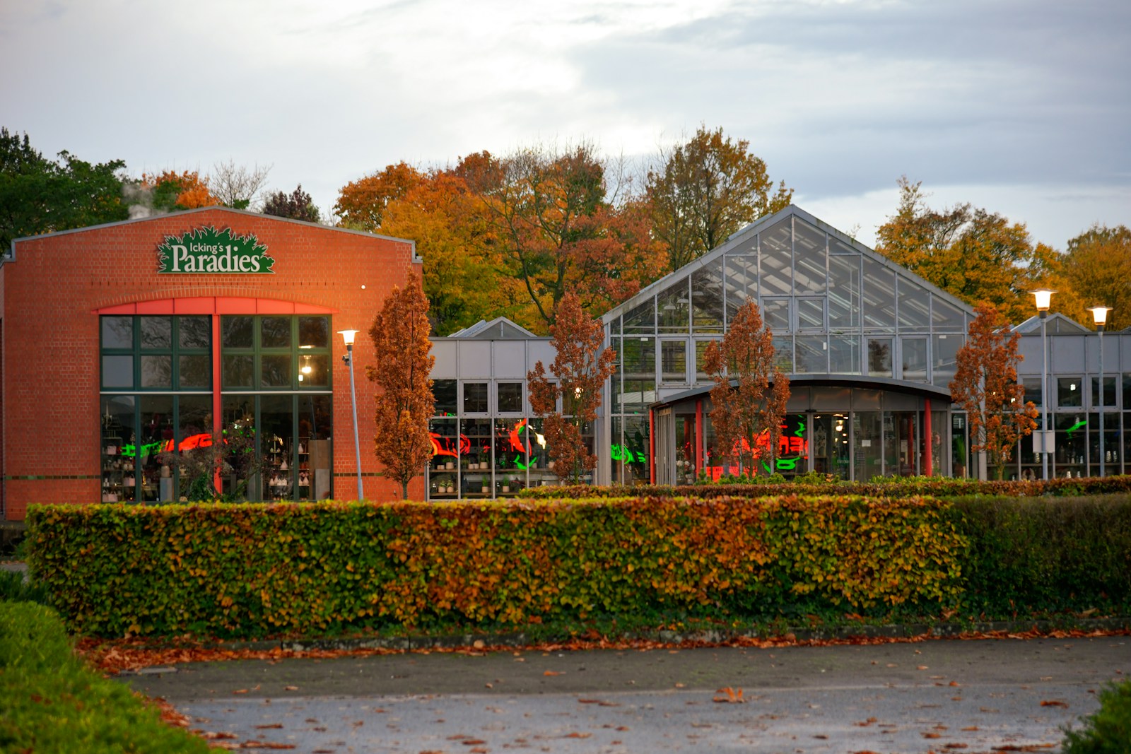 Modern buildings with greenhouse structure and autumn trees